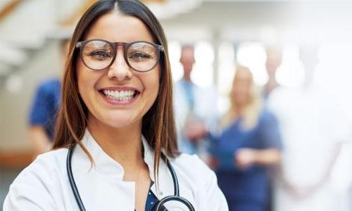 Family nurse practitioner with DNP smiling with team of medical professionals 